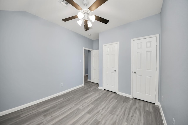 unfurnished bedroom featuring visible vents, baseboards, a ceiling fan, and wood finished floors