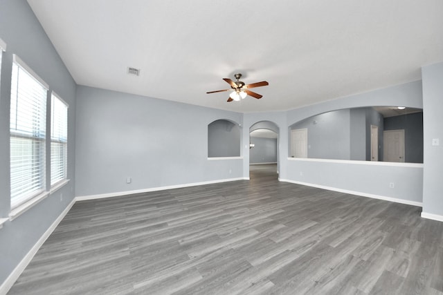 unfurnished living room with ceiling fan, baseboards, wood finished floors, and visible vents
