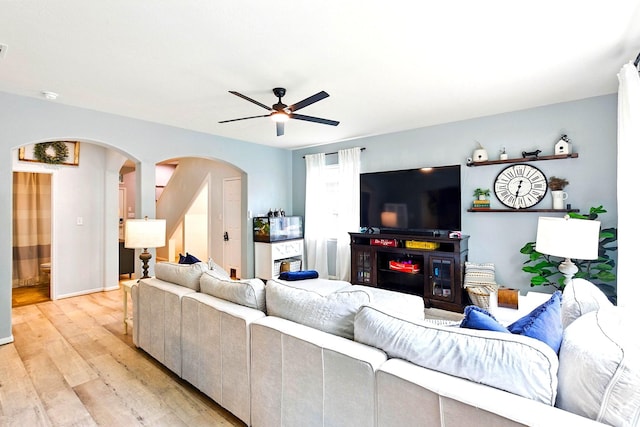 16611 River Wood Ct, Crosby, TX 77532 - living area featuring baseboards, arched walkways, ceiling fan, and light wood-style floors