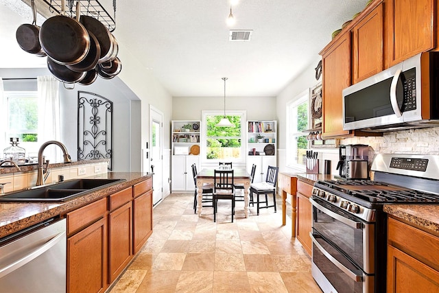 16611 River Wood Ct, Crosby, TX 77532 - kitchen featuring brown cabinets, a sink, appliances with stainless steel finishes, and visible vents