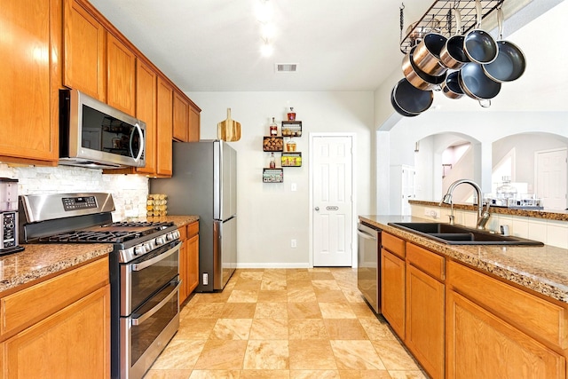 16611 River Wood Ct, Crosby, TX 77532 - kitchen featuring a sink, visible vents, backsplash, arched walkways, and appliances with stainless steel finishes