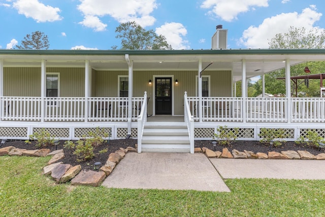 view of front of house featuring covered porch and a chimney