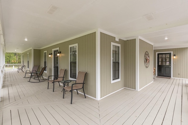 wooden deck featuring visible vents and covered porch