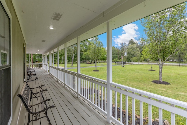 wooden terrace with a porch, a yard, and visible vents