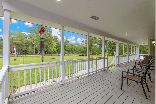 wooden deck featuring visible vents and a yard