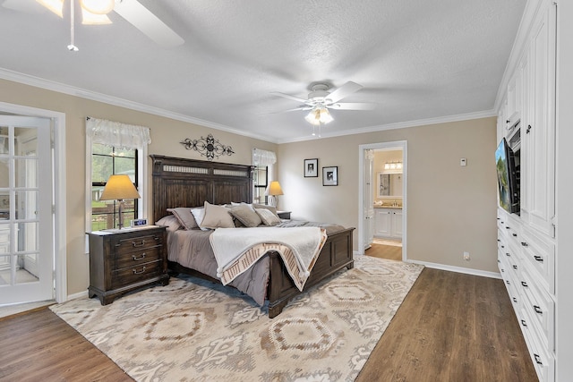 bedroom featuring a textured ceiling, wood finished floors, crown molding, and baseboards