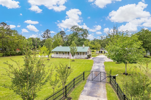 exterior space featuring driveway, fence, a gate, and a yard