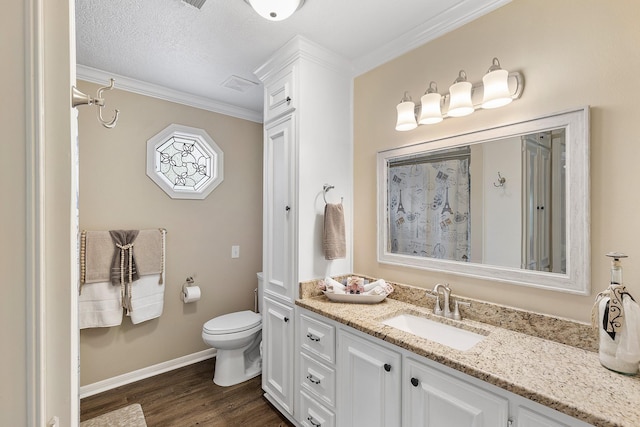 bathroom with crown molding, baseboards, toilet, wood finished floors, and vanity
