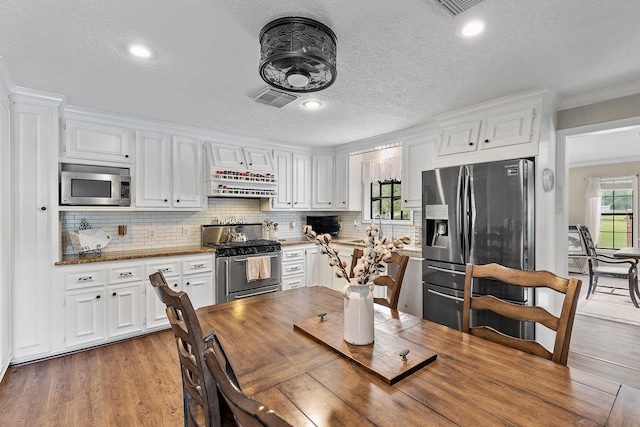 kitchen featuring light wood-style flooring, visible vents, appliances with stainless steel finishes, and white cabinetry