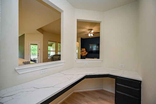 interior space with wood finished floors, ceiling fan, and built in desk