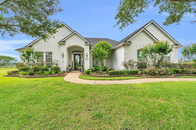 ranch-style house featuring brick siding and a front lawn