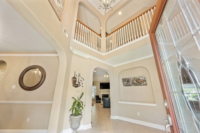 3719 Arundel Gardens Ln, Sugar Land, TX 77498 - foyer entrance with arched walkways, tile patterned flooring, a high ceiling, baseboards, and a fireplace