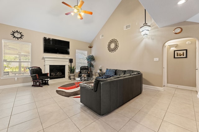 3719 Arundel Gardens Ln, Sugar Land, TX 77498 - living room featuring a ceiling fan, arched walkways, light tile patterned floors, high vaulted ceiling, and a fireplace