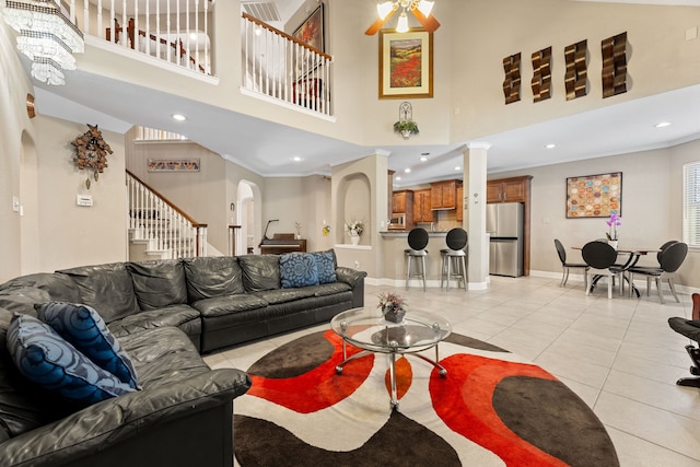 3719 Arundel Gardens Ln, Sugar Land, TX 77498 - living room with arched walkways, a high ceiling, stairs, light tile patterned floors, and recessed lighting