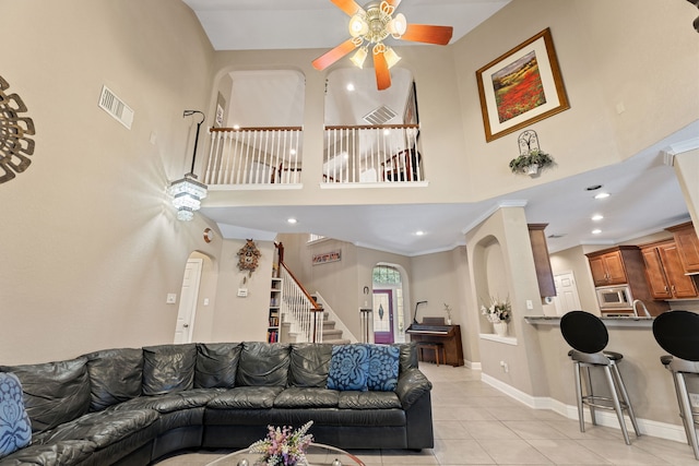 3719 Arundel Gardens Ln, Sugar Land, TX 77498 - living room featuring light tile patterned floors, stairway, arched walkways, a ceiling fan, and recessed lighting