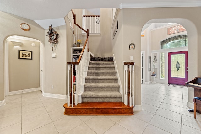 3719 Arundel Gardens Ln, Sugar Land, TX 77498 - entrance foyer with arched walkways, tile patterned floors, stairs, and baseboards