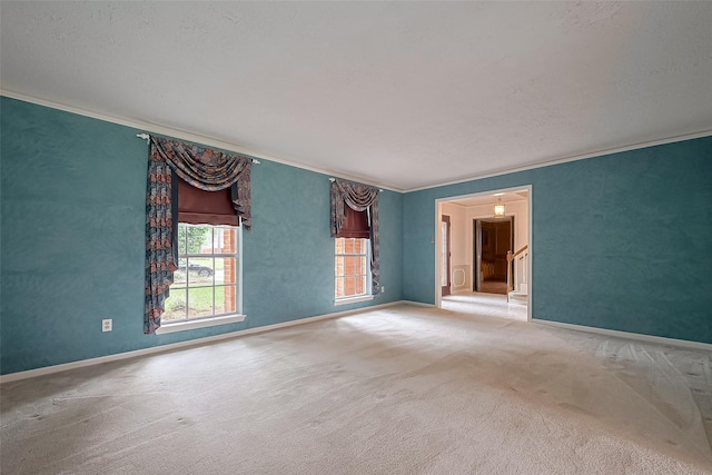empty room featuring ornamental molding, carpet floors, and baseboards