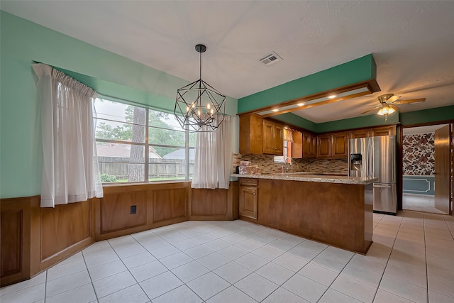 kitchen featuring light tile patterned floors, visible vents, stainless steel refrigerator with ice dispenser, a peninsula, and brown cabinetry