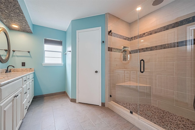 bathroom with vanity, a stall shower, and baseboards