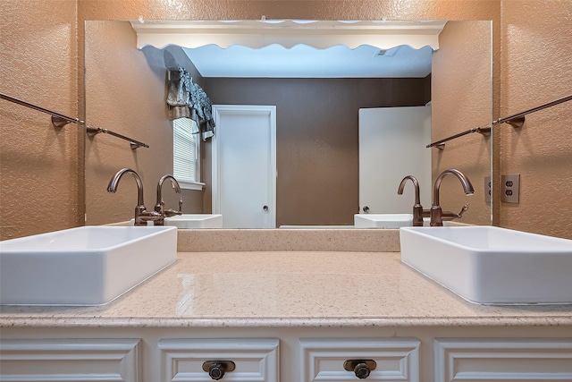 bathroom featuring a textured wall and vanity