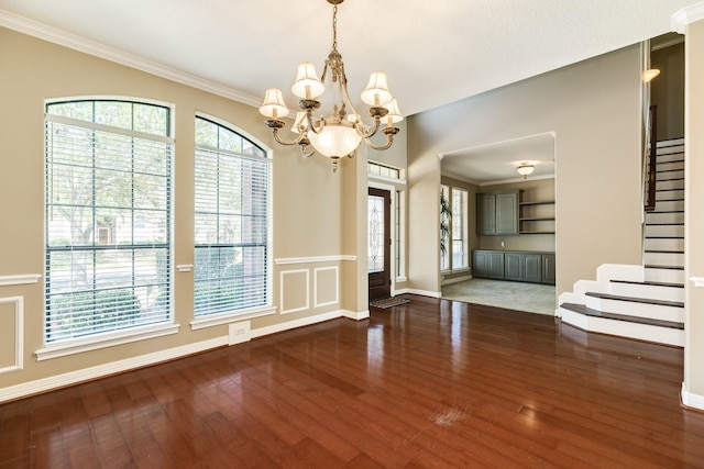 51 Scotch Pine Ct, Lake Jackson, TX 77566 - unfurnished dining area featuring crown molding, stairway, baseboards, an inviting chandelier, and wood finished floors