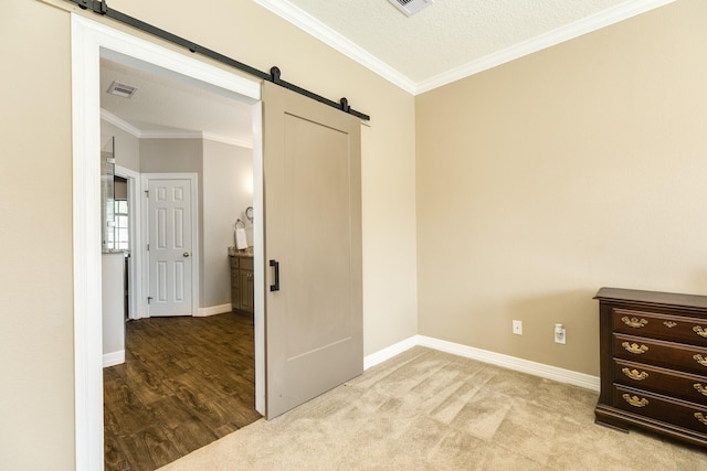 51 Scotch Pine Ct, Lake Jackson, TX 77566 - empty room with ornamental molding, visible vents, a barn door, and baseboards