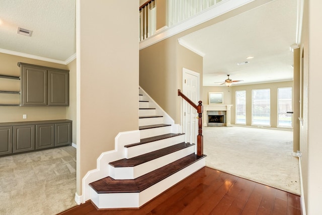 51 Scotch Pine Ct, Lake Jackson, TX 77566 - stairs featuring ornamental molding, a ceiling fan, hardwood / wood-style flooring, and carpet flooring