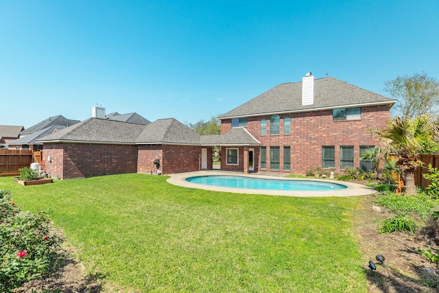 51 Scotch Pine Ct, Lake Jackson, TX 77566 - rear view of property featuring brick siding, a lawn, fence private yard, and a chimney