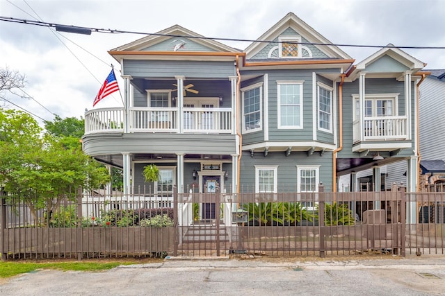 1220 Bingham St, Houston, TX 77007 - view of front of house featuring a balcony, covered porch, a fenced front yard, and a ceiling fan