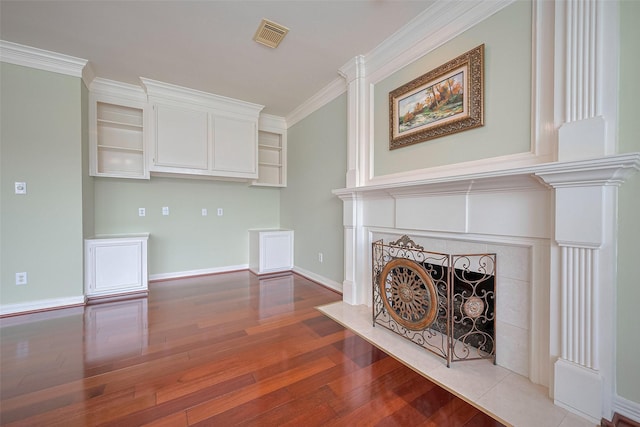 unfurnished living room featuring a fireplace, visible vents, baseboards, ornamental molding, and wood finished floors