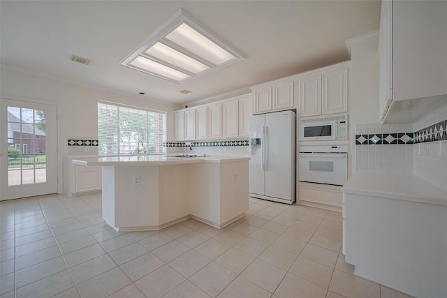 kitchen with a center island, light tile patterned flooring, visible vents, and white appliances