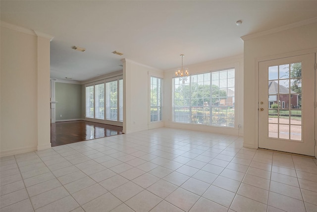 unfurnished room with a chandelier, light tile patterned floors, crown molding, visible vents, and baseboards