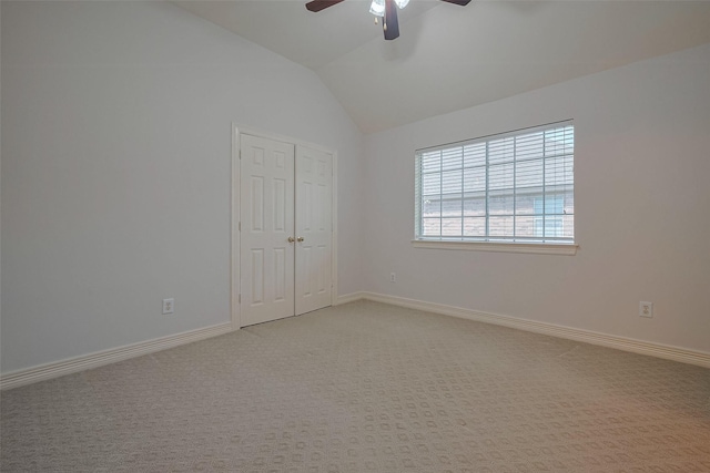 unfurnished room with a ceiling fan, light carpet, lofted ceiling, and baseboards