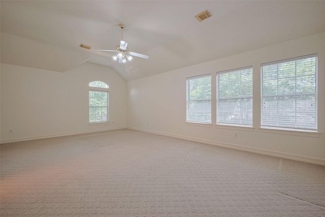 unfurnished room with a ceiling fan, visible vents, lofted ceiling, and baseboards