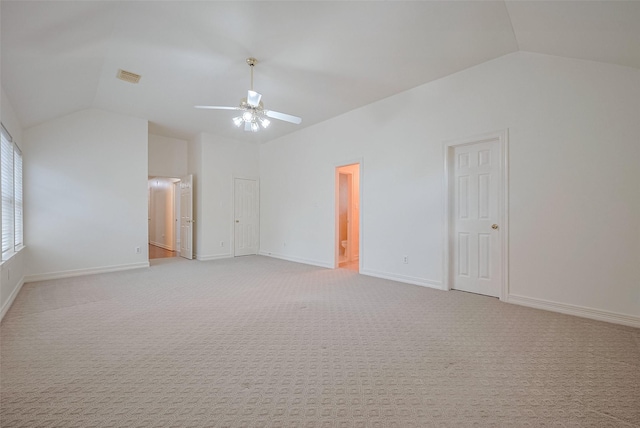 spare room with a ceiling fan, visible vents, lofted ceiling, and baseboards