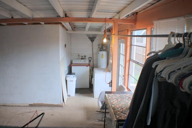 interior space featuring washing machine and clothes dryer, plenty of natural light, and gas water heater
