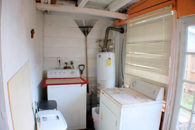 laundry room featuring laundry area, water heater, and washing machine and dryer