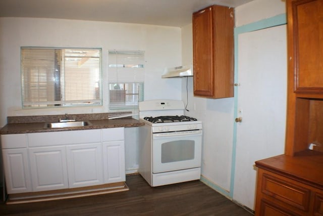 4334 Bell St, Houston, TX 77023 - kitchen with white range with gas cooktop, under cabinet range hood, dark wood-style floors, dark countertops, and white cabinets