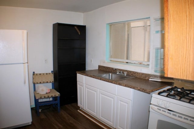 4334 Bell St, Houston, TX 77023 - kitchen featuring white appliances, dark wood-type flooring, dark countertops, and white cabinets