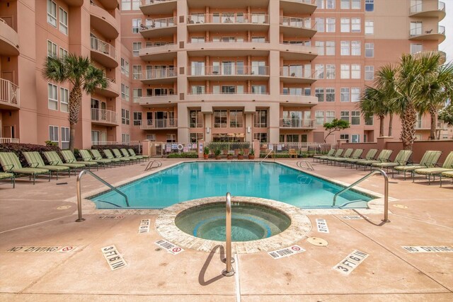 community pool featuring a patio area and a hot tub