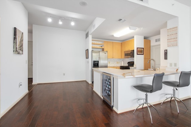 kitchen featuring tasteful backsplash, stainless steel appliances, dark wood-style floors, a peninsula, and wine cooler