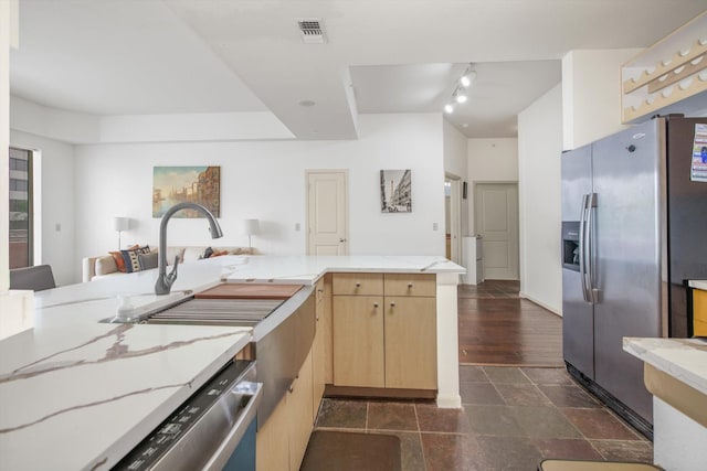 kitchen featuring stainless steel appliances, light brown cabinetry, visible vents, light stone counters, and open floor plan