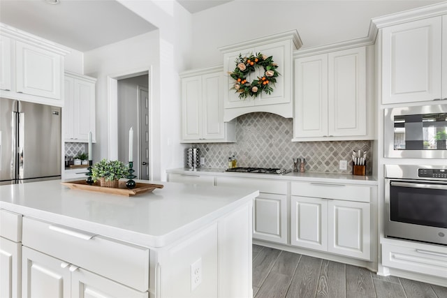 kitchen featuring decorative backsplash, white cabinets, light wood-style floors, stainless steel appliances, and light countertops