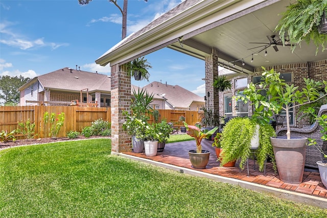 view of yard with a patio area, ceiling fan, and a fenced backyard