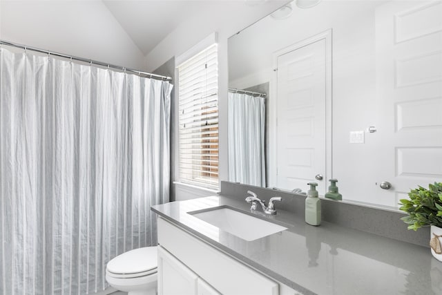 bathroom featuring a wealth of natural light, toilet, vanity, and vaulted ceiling