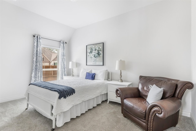 bedroom featuring lofted ceiling, light colored carpet, and baseboards