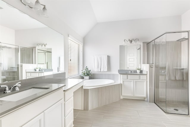 bathroom featuring a stall shower, a sink, and vaulted ceiling
