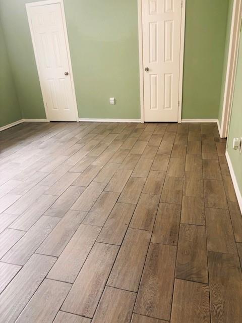unfurnished bedroom with wood finished floors and baseboards
