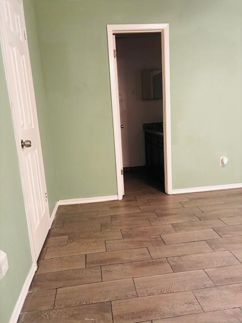 spare room featuring wood finished floors and baseboards