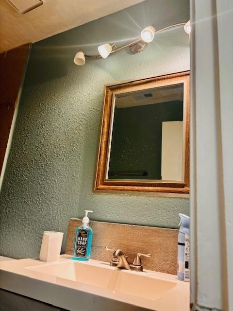 bathroom with a sink and a textured wall